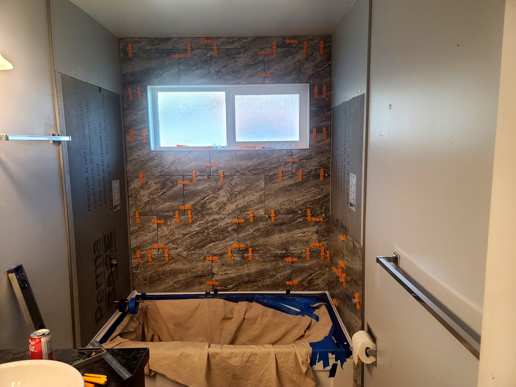 Bathroom tub surround with waterproofing and tile backer work underway