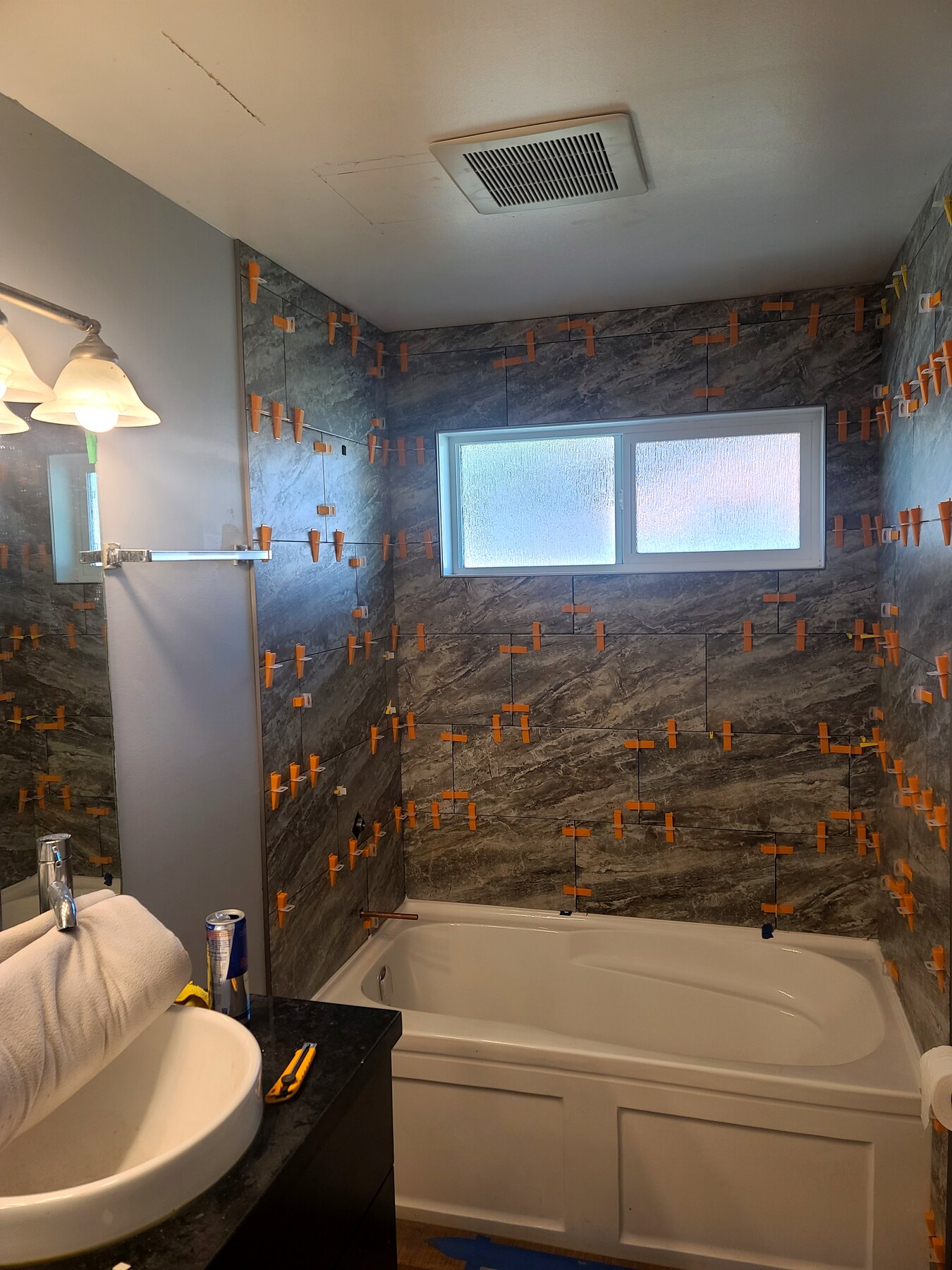 Bathroom tub surround with tile installation underway