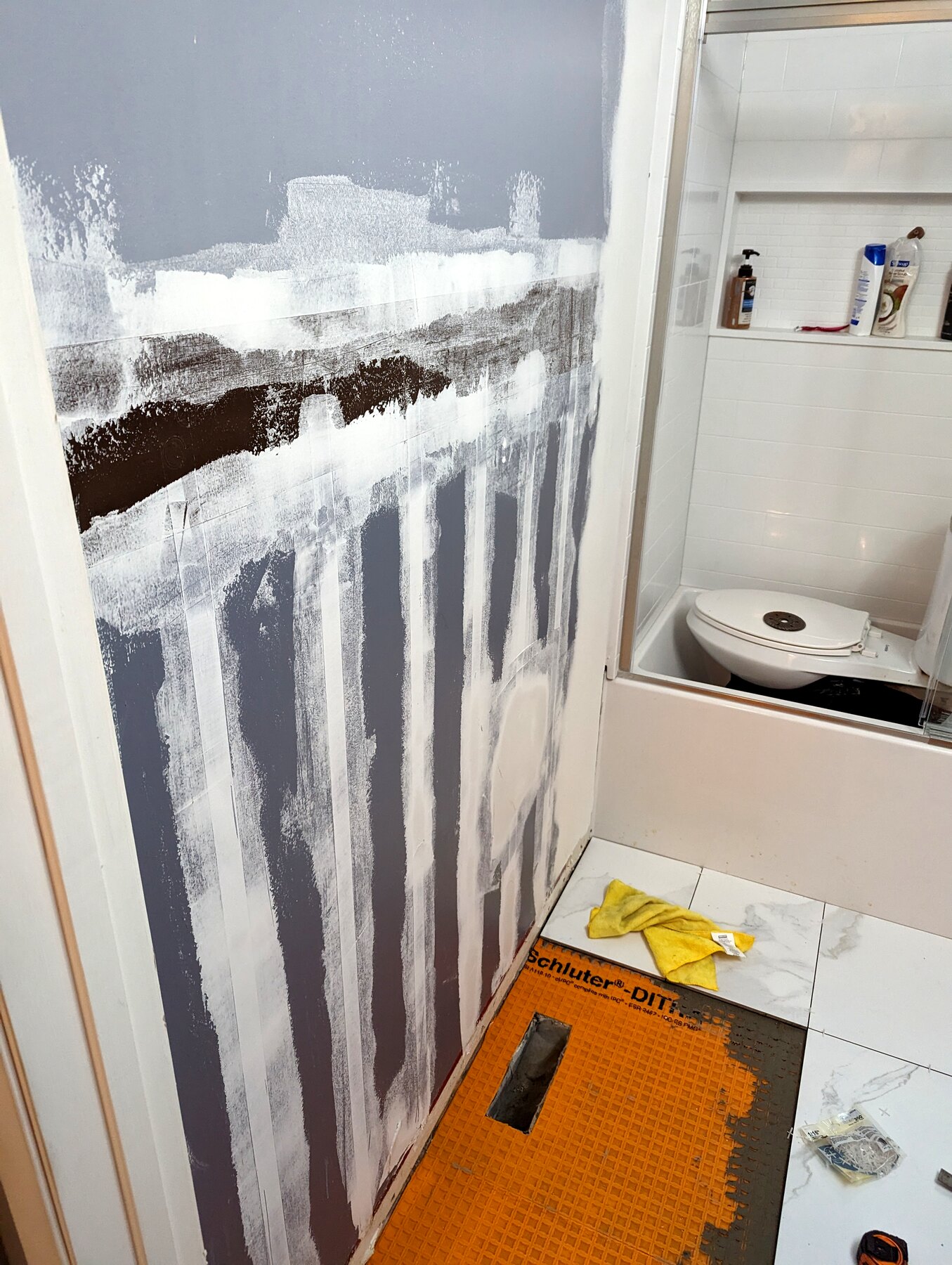 Bathroom wall and floor with waterproofing membrane and finish work underway