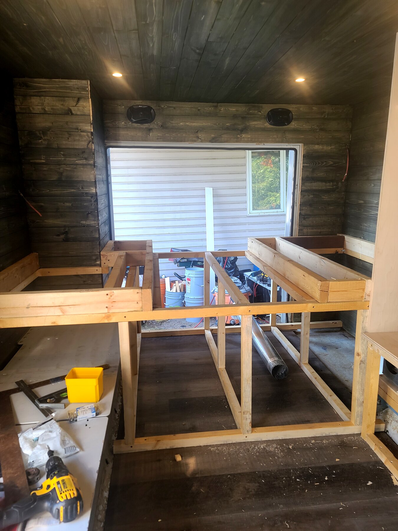 Framed built-in storage structure with tools visible on site