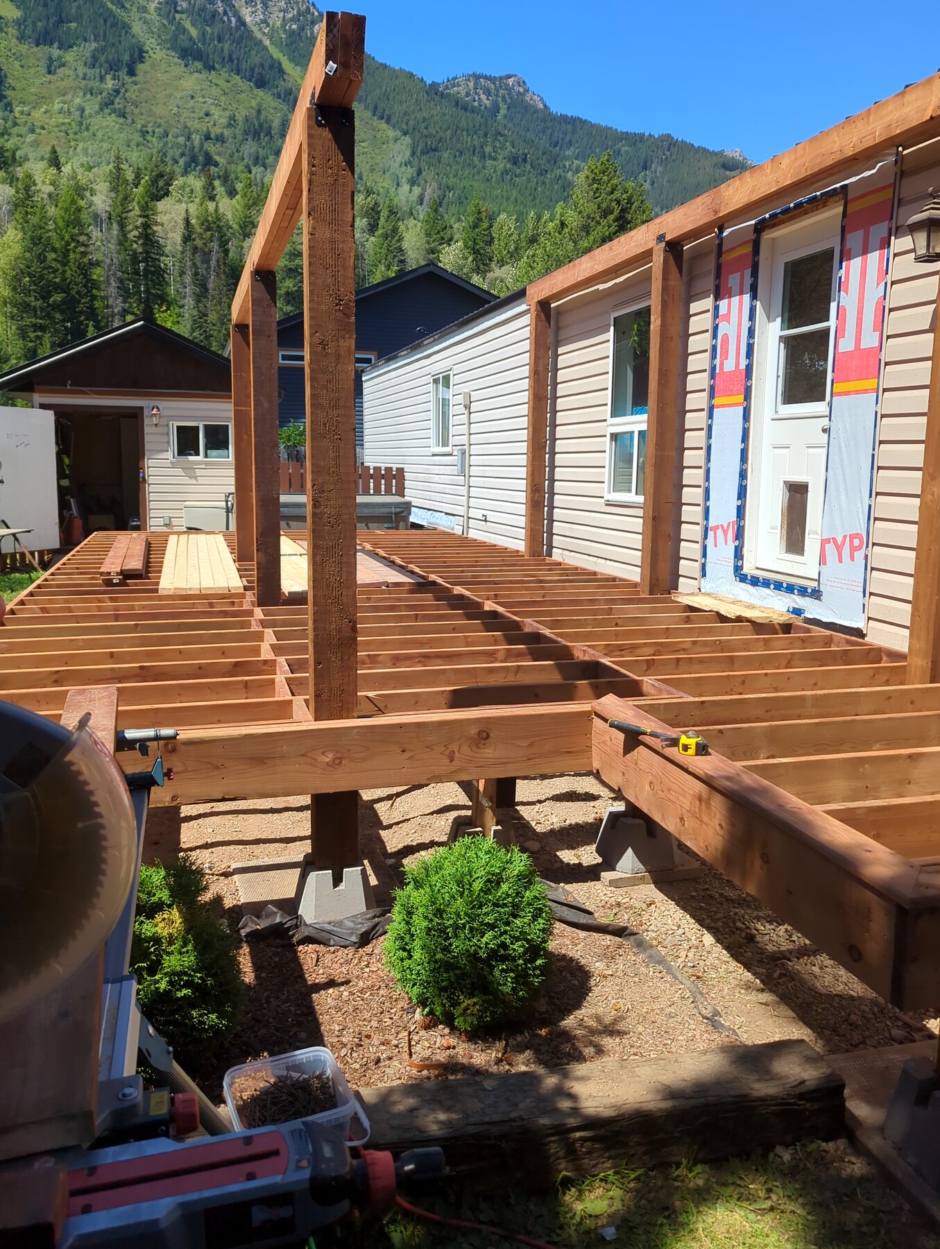 Deck framing and posts alongside a manufactured home