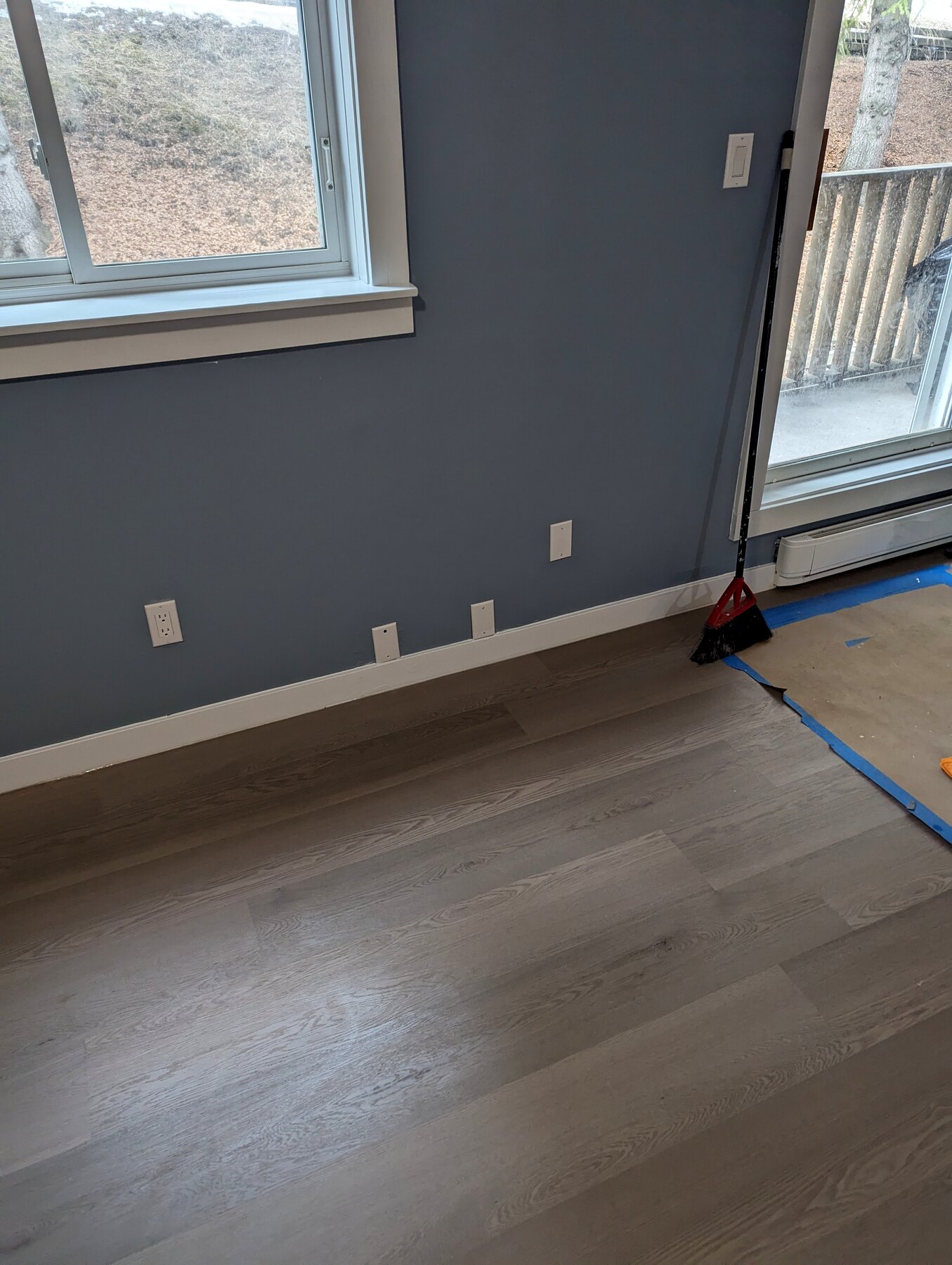 Painted room with finished flooring beside a window and door