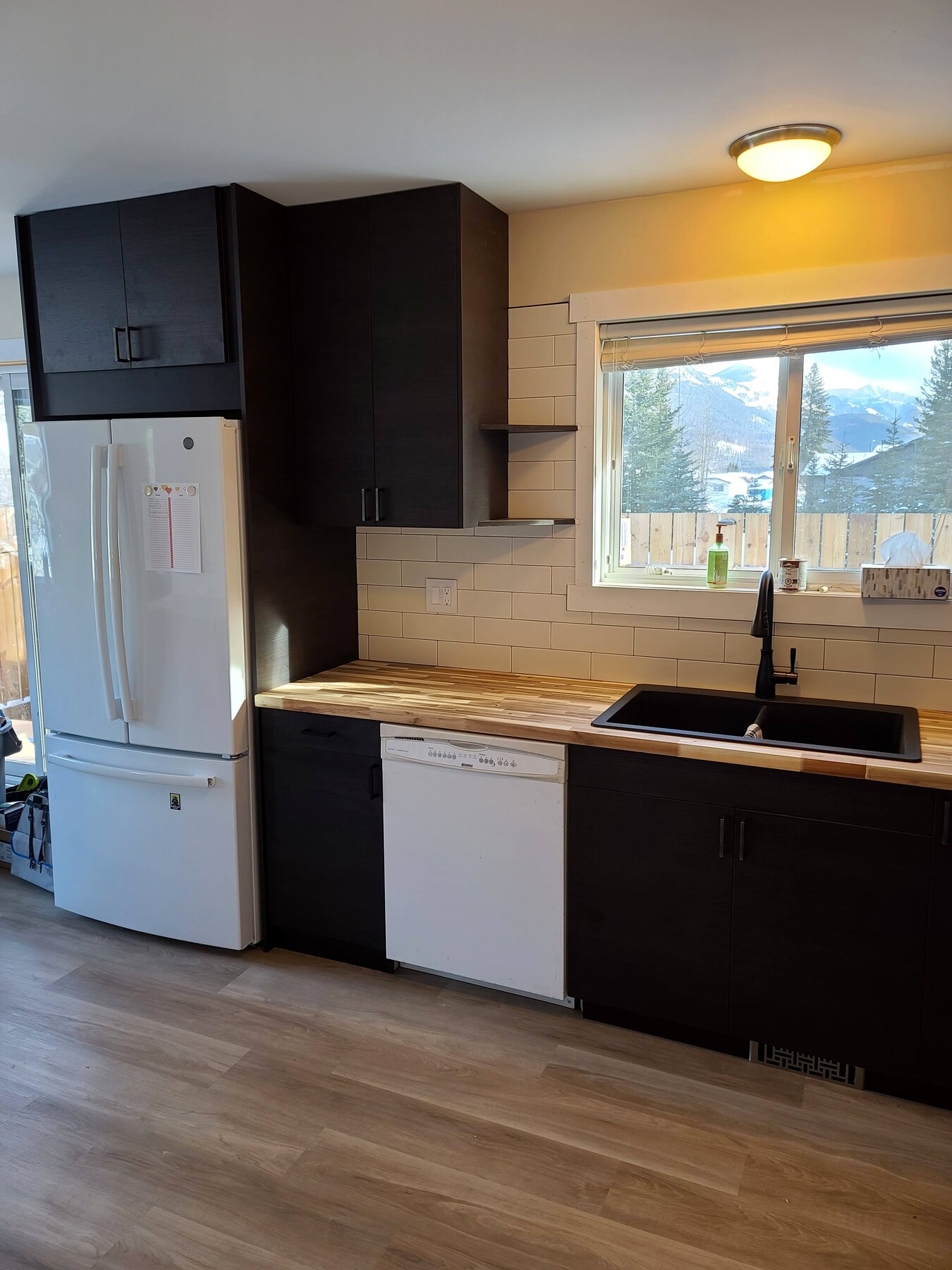 Kitchen renovation in Sparwood — dark cabinetry, counters, and wood-look flooring