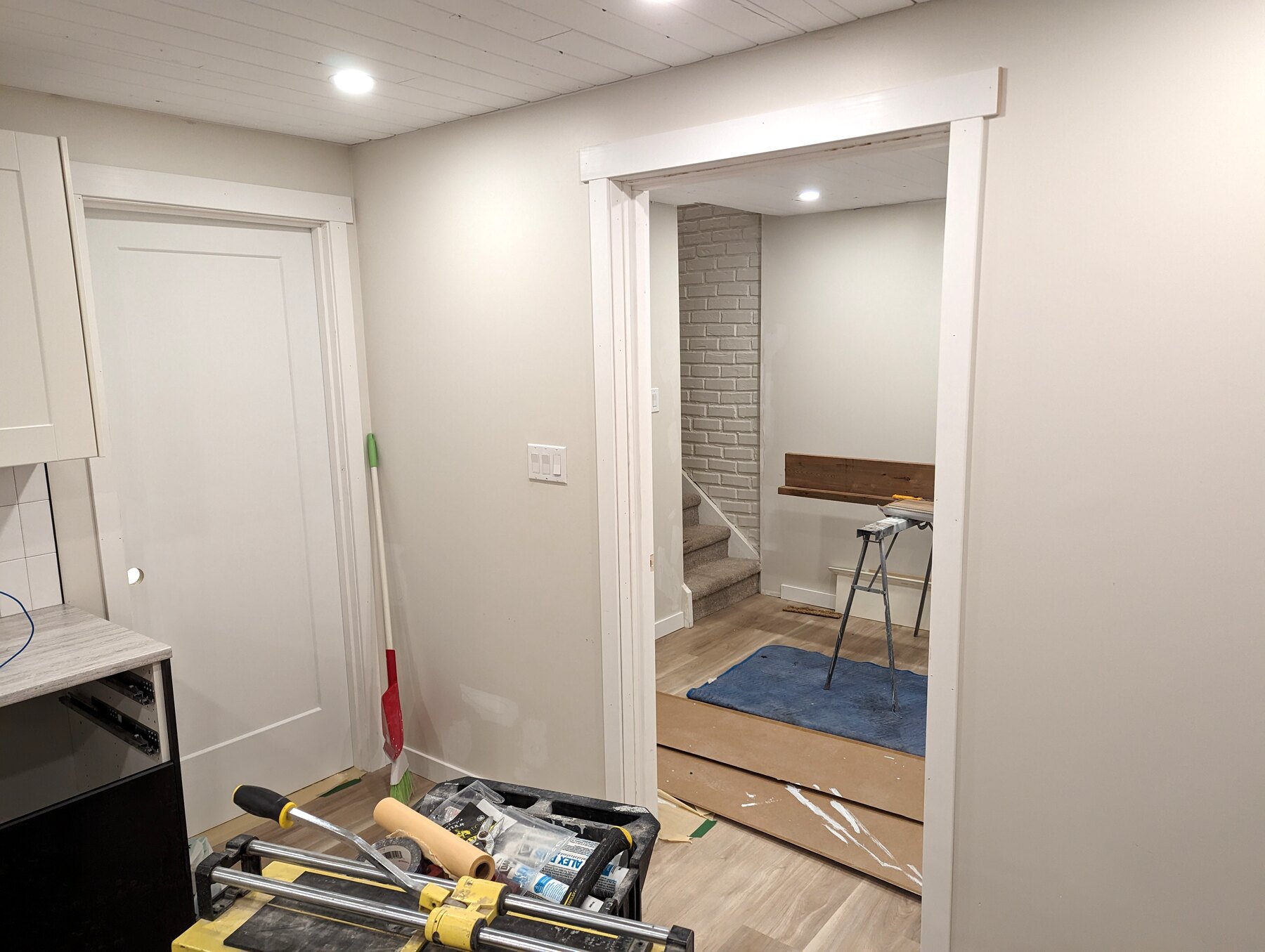 Kitchen cabinetry and open storage with tools visible at the work area