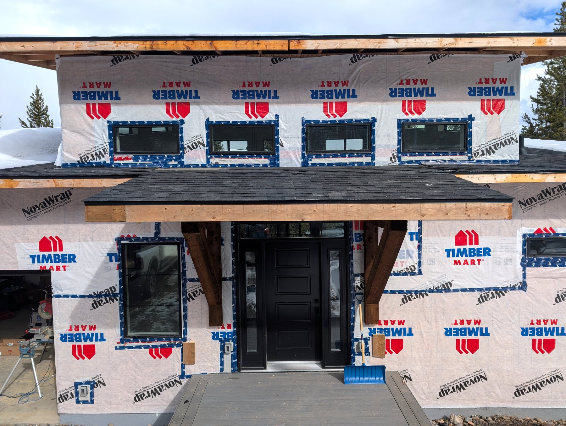 New-build exterior with wrapped walls, entry, and unfinished roof edges