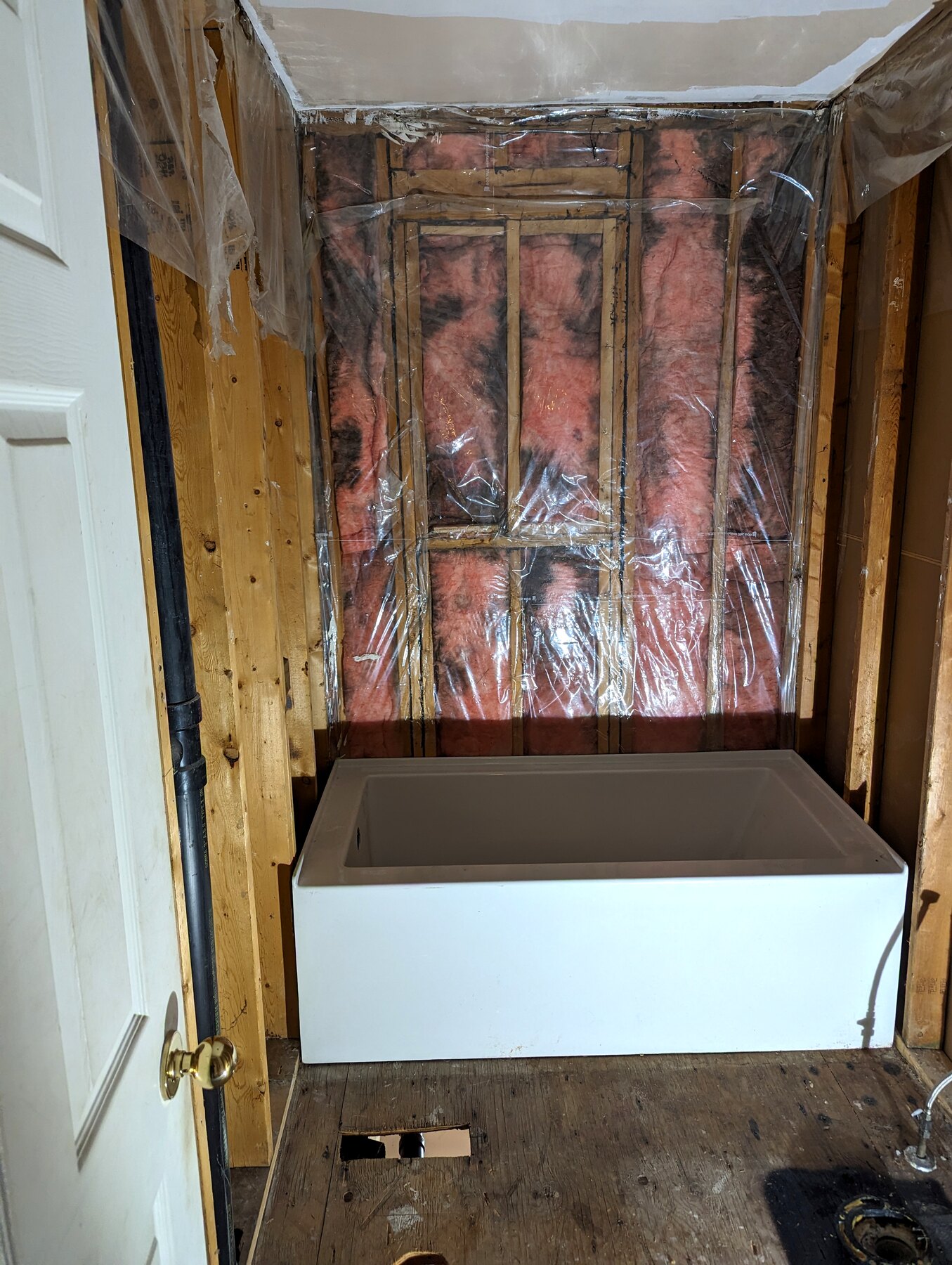 Bathroom shower wall framing with plumbing visible