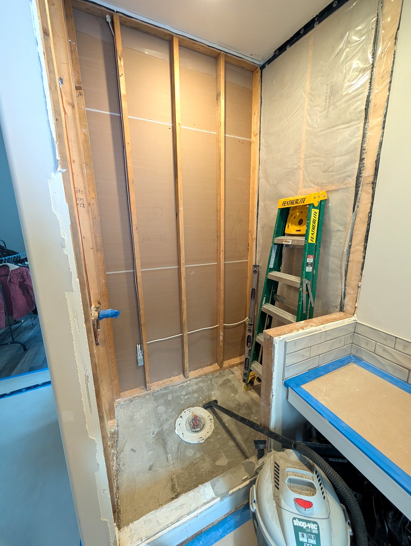 Bathroom shower area with wall framing and waterproofing work underway