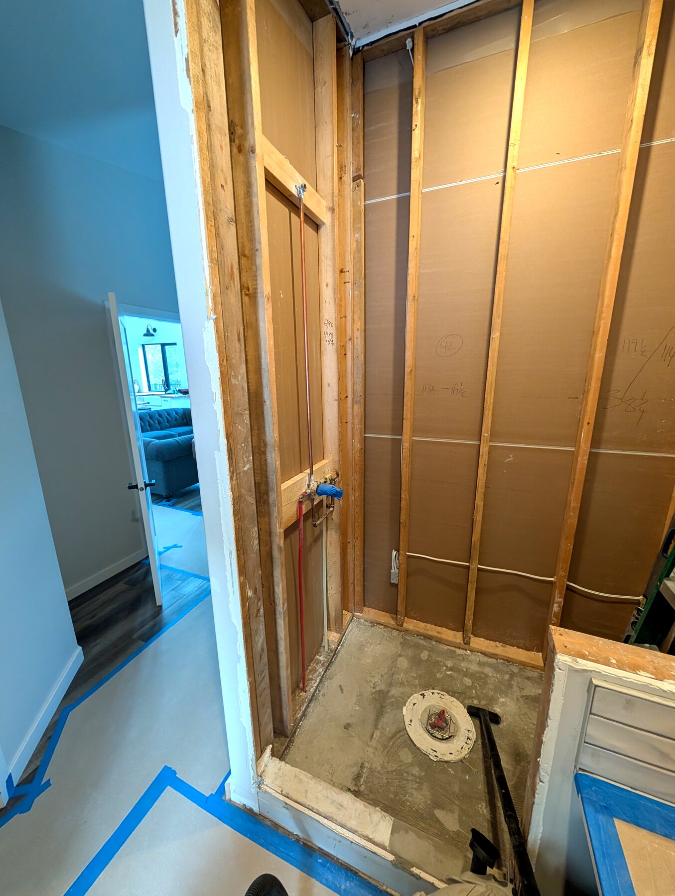 Bathroom shower area with framing and floor protection in place