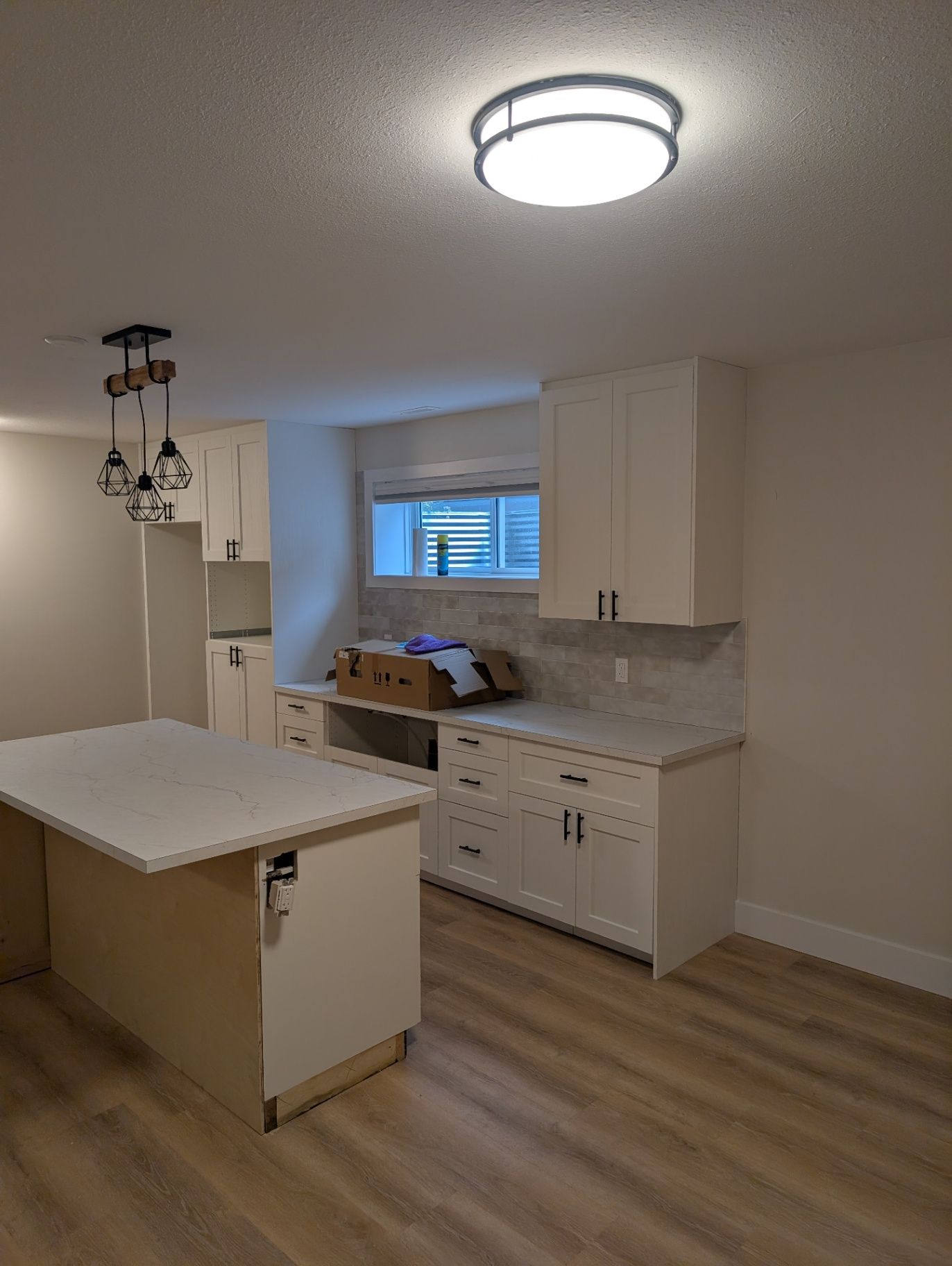 View of the kitchen cabinetry, island, and open floor area