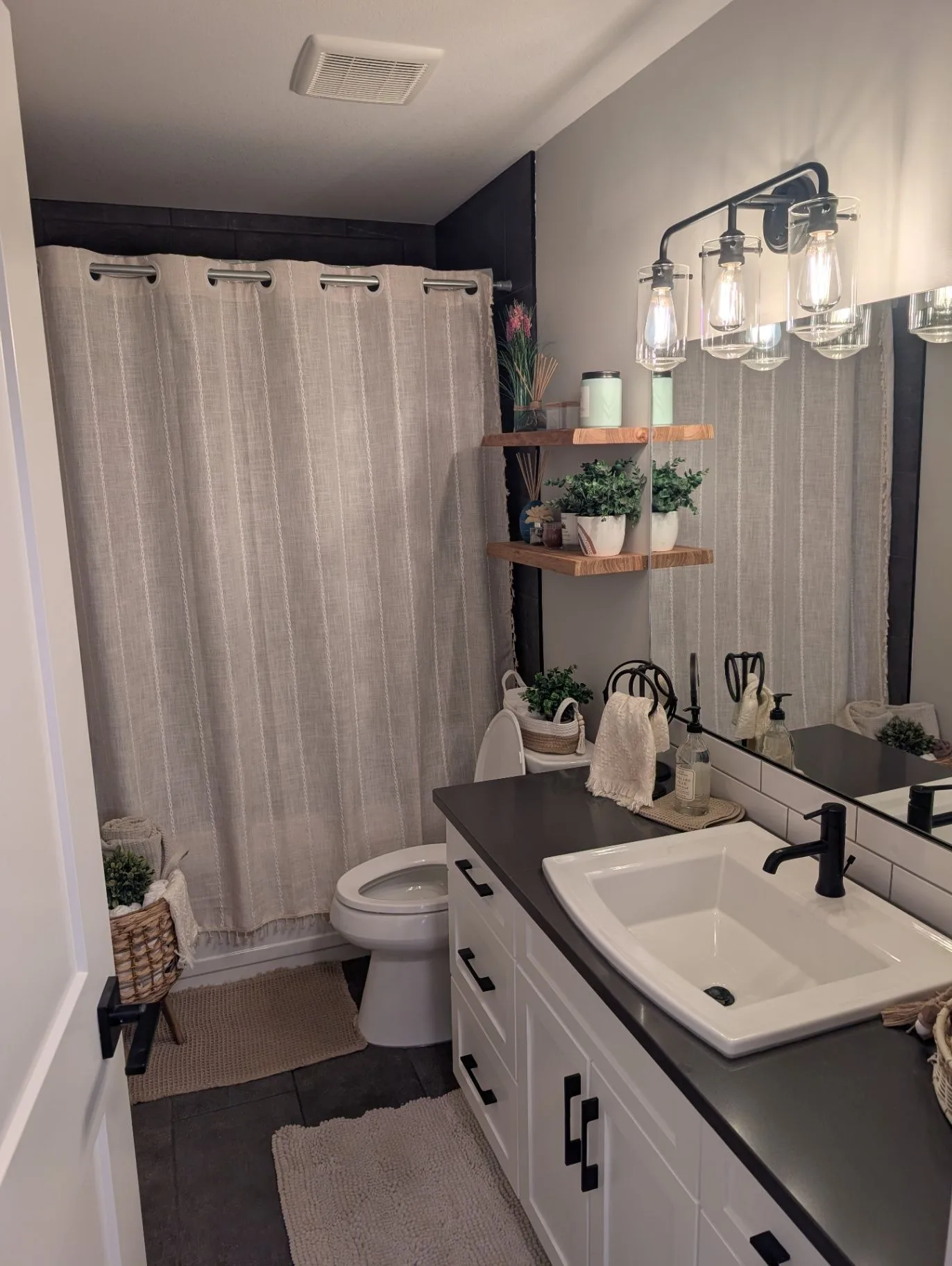 Basement bathroom with vanity, mirror, and bathtub