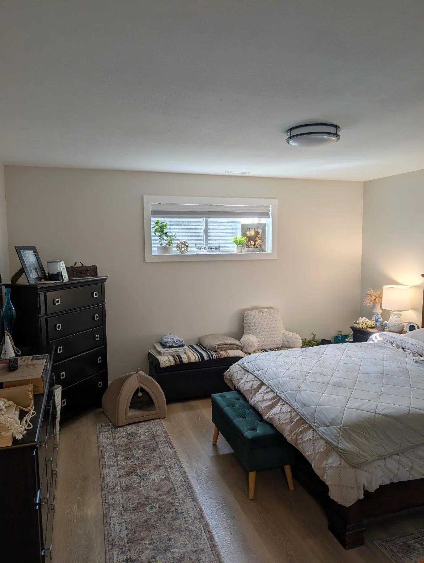 Basement bedroom with bed, dresser, and window