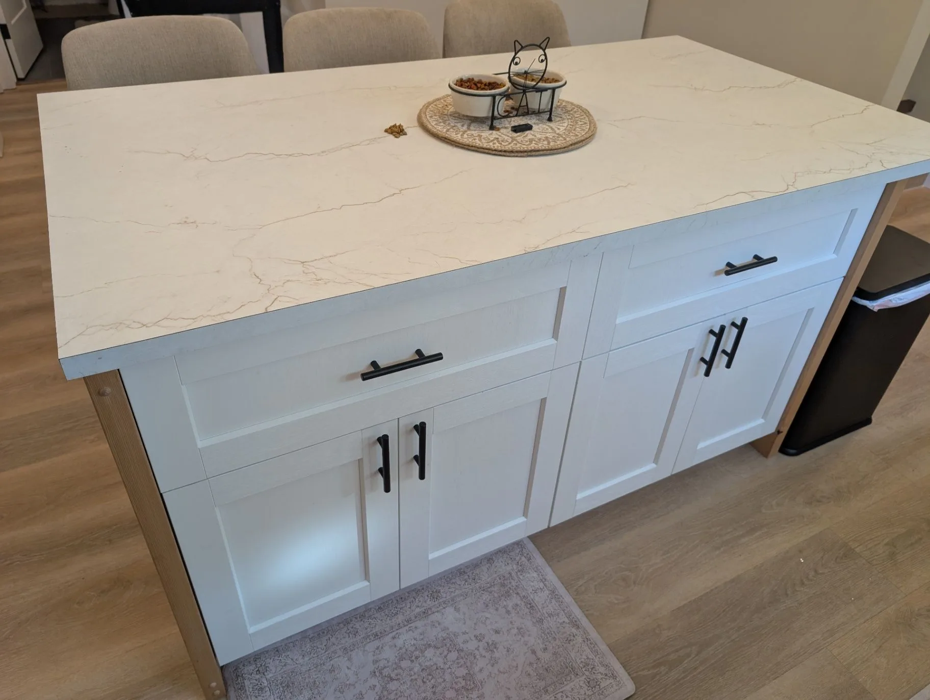 Close view of the kitchen island surface and white cabinetry