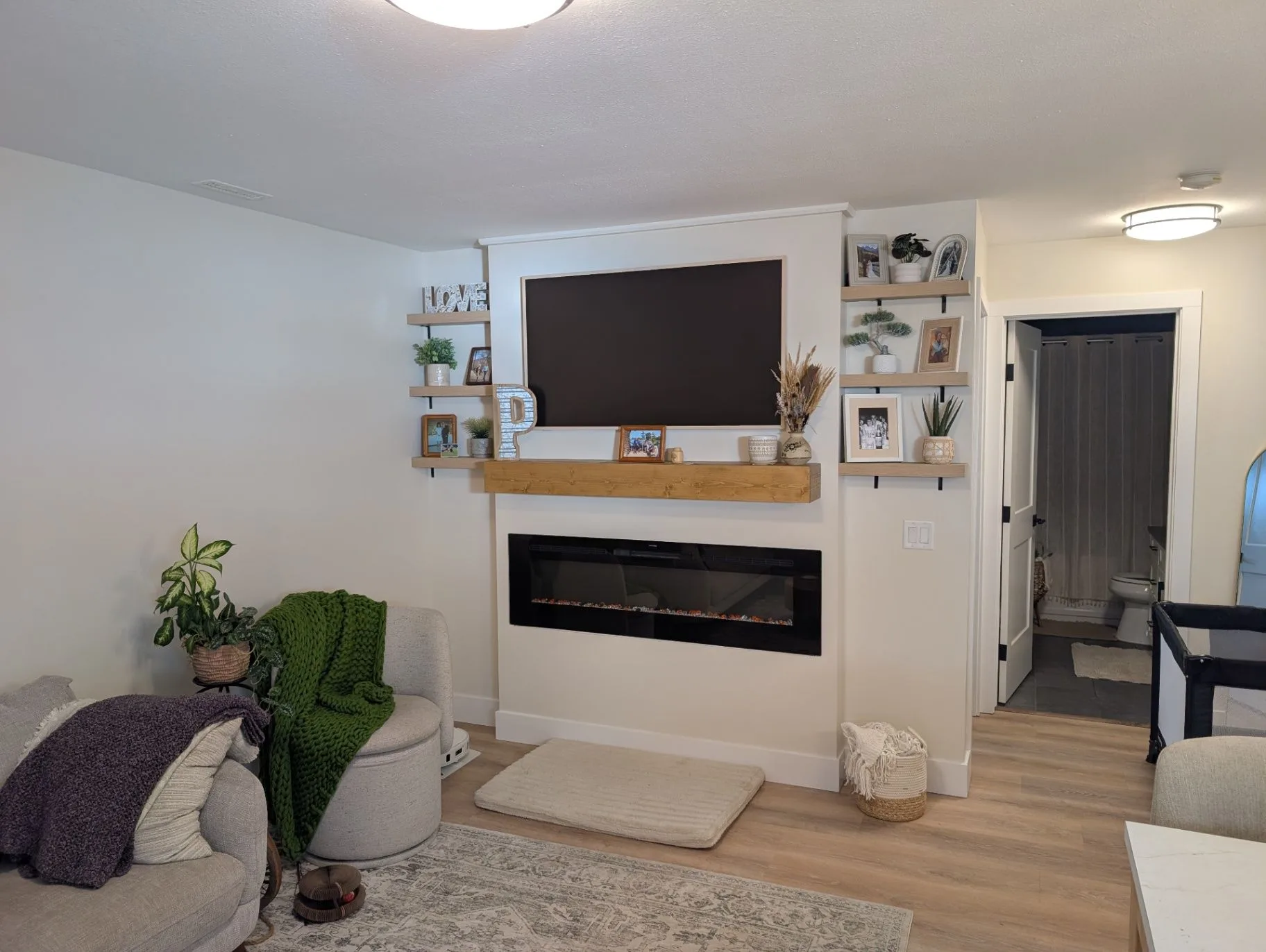 Basement renovation in Elkford — completed fireplace and media wall with open shelving