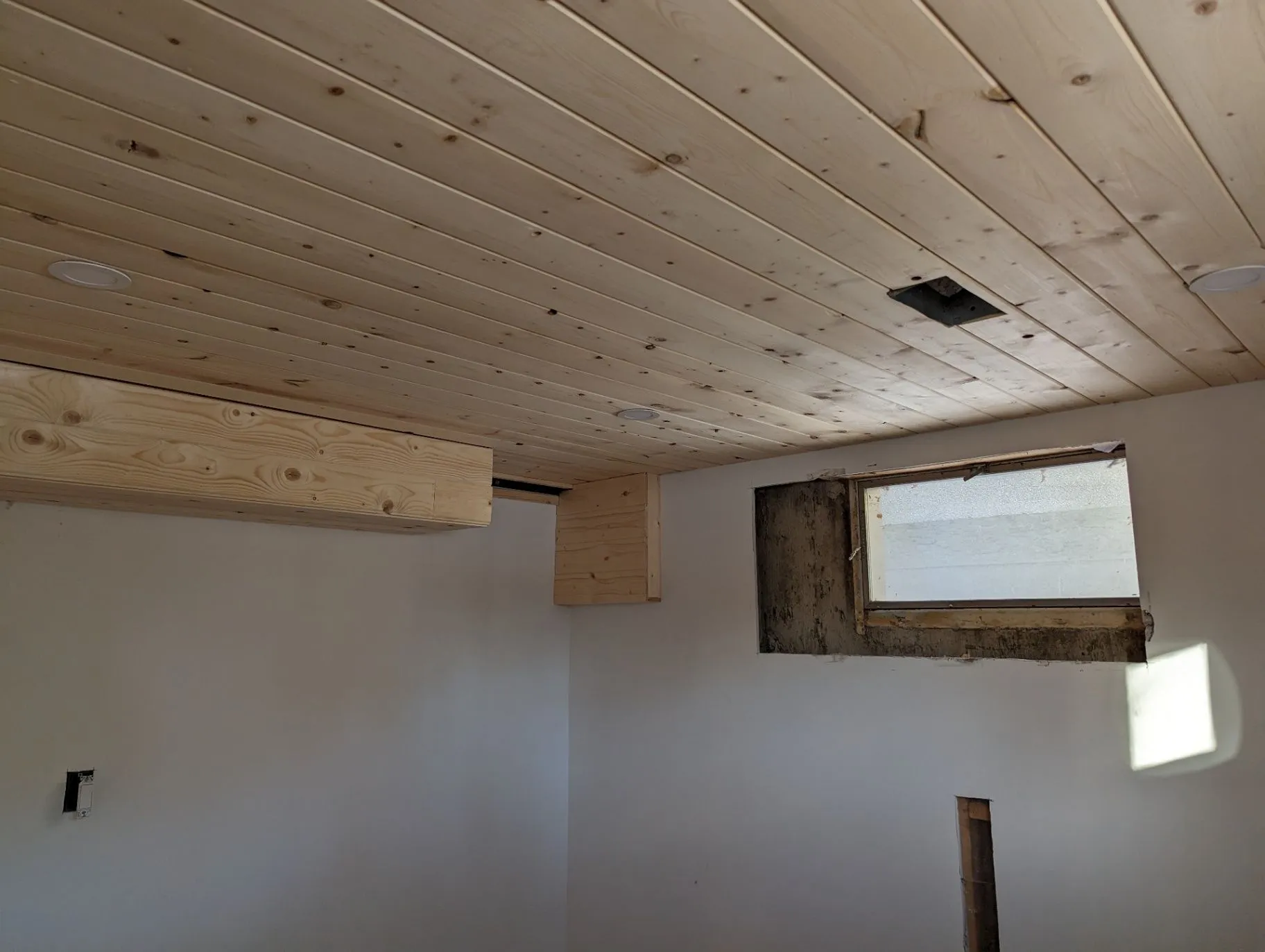 Wood-plank ceiling installation in a basement room