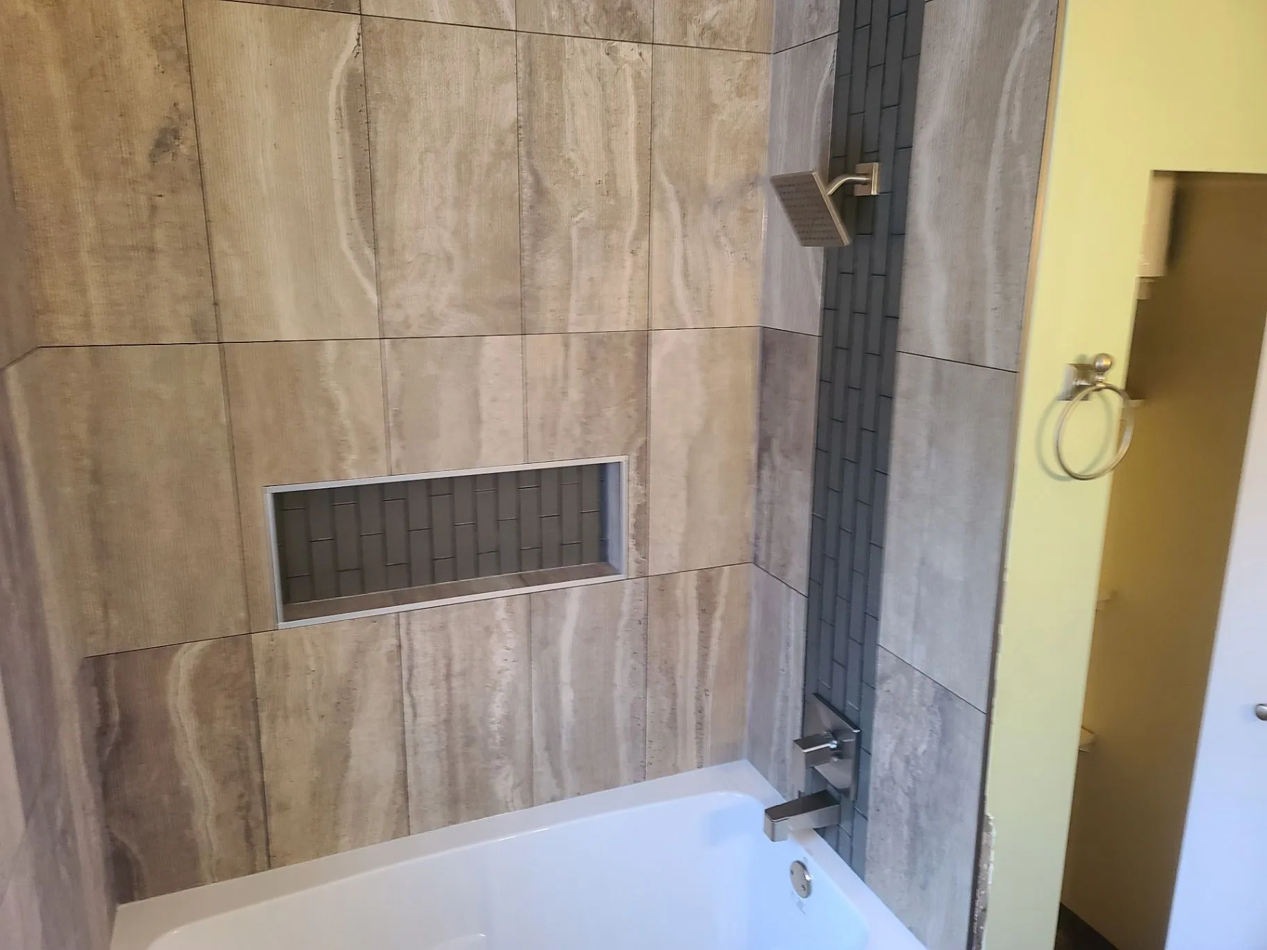 Marble-look tile on a completed bathroom shower wall