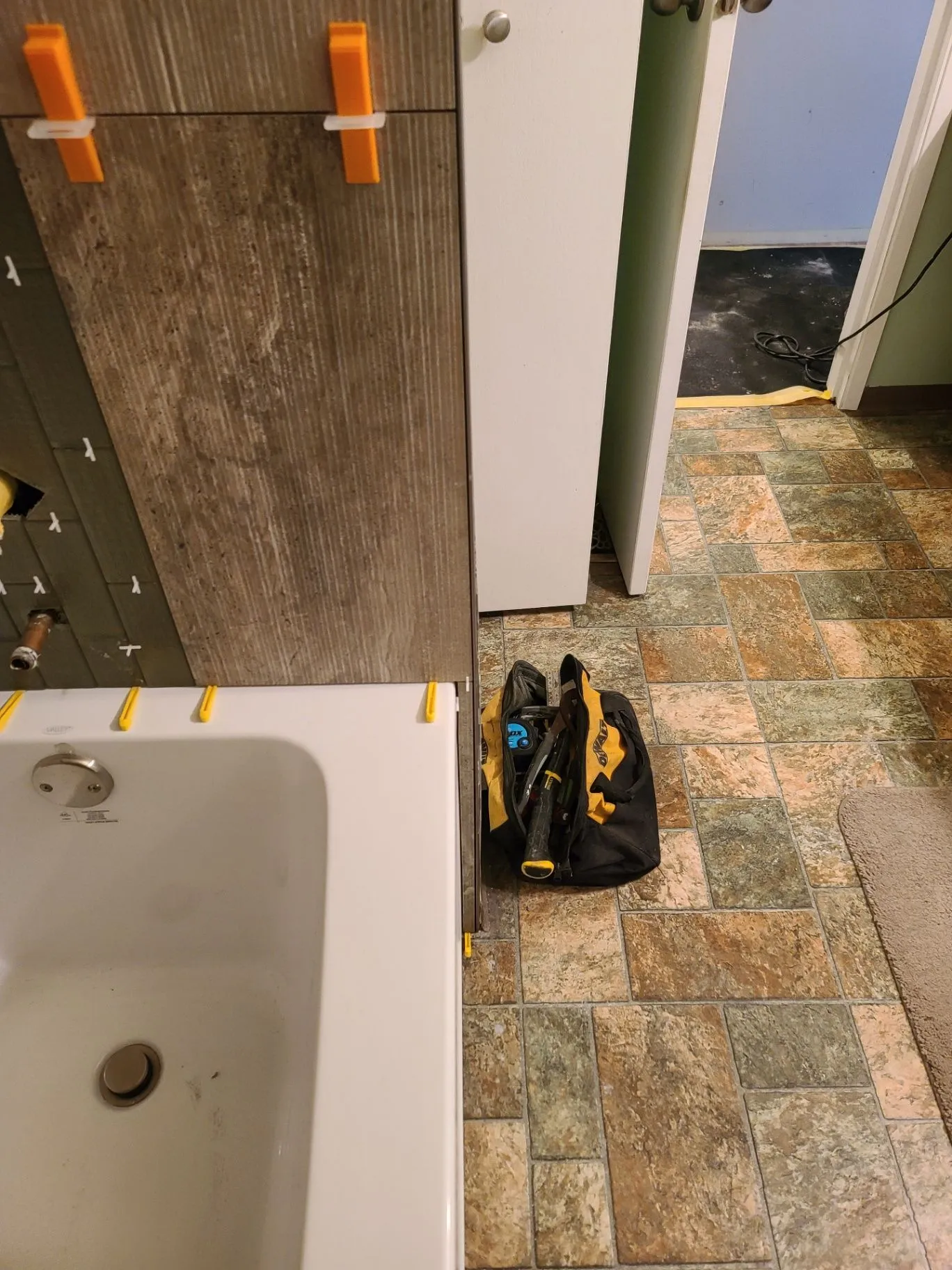 Bathroom wall tile being set with spacers around a tub