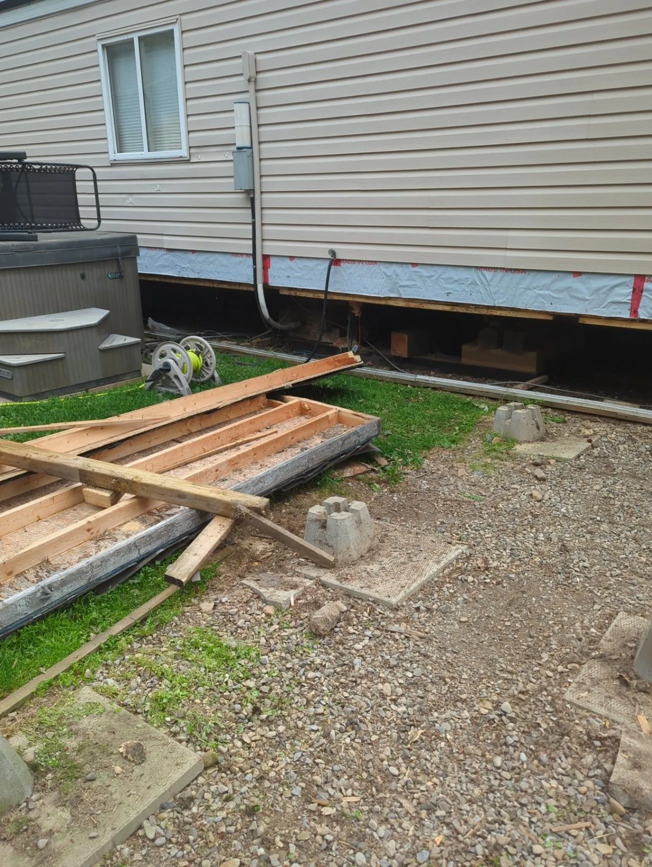 Lumber and exterior work staged beside a residential building