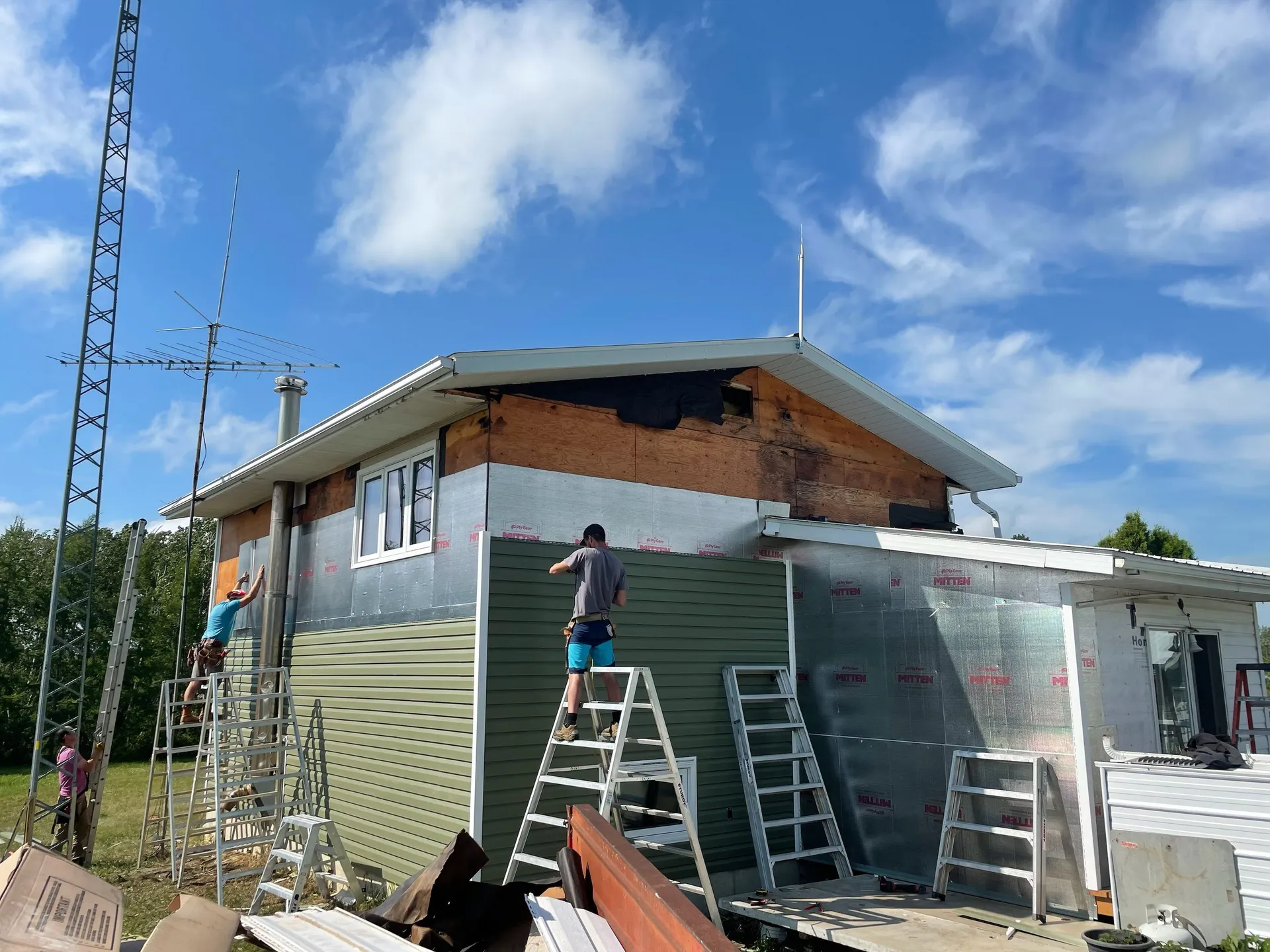 Residential exterior with roofline and siding work underway