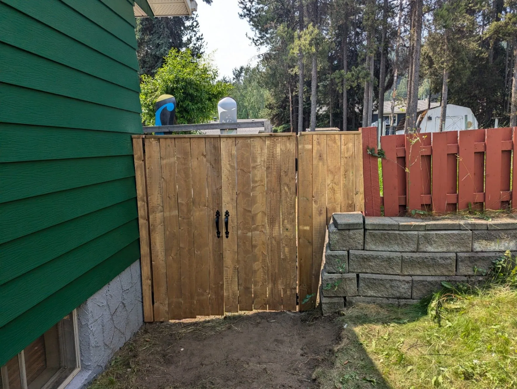 Completed wooden fence gate beside a residential yard