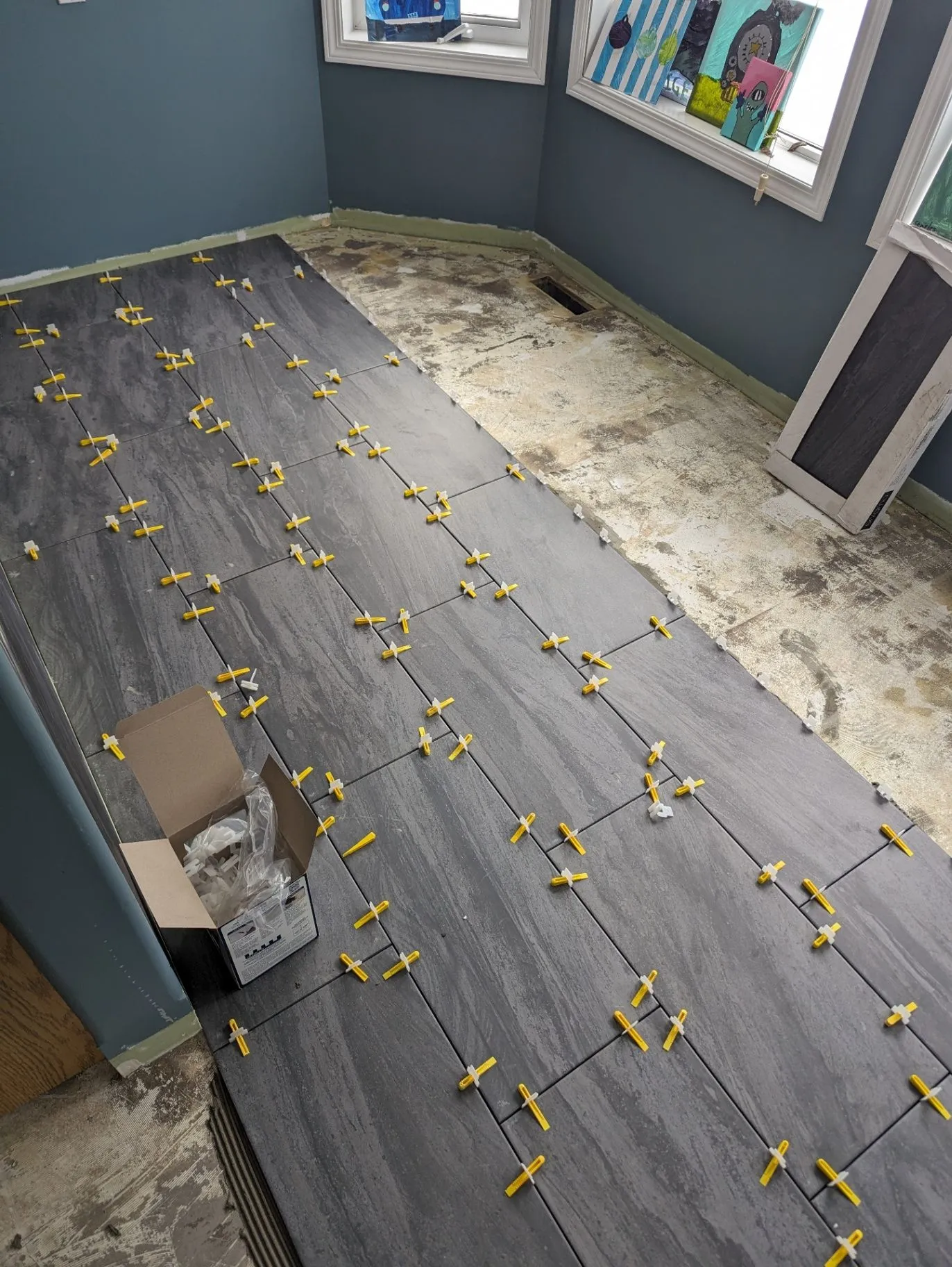 Large floor tiles being installed with levelling clips