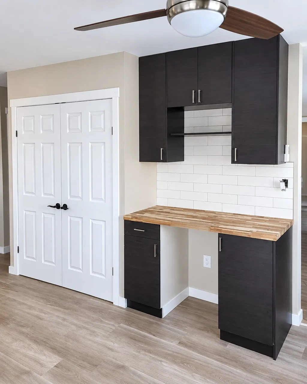 Dark cabinet kitchen with white tile backsplash