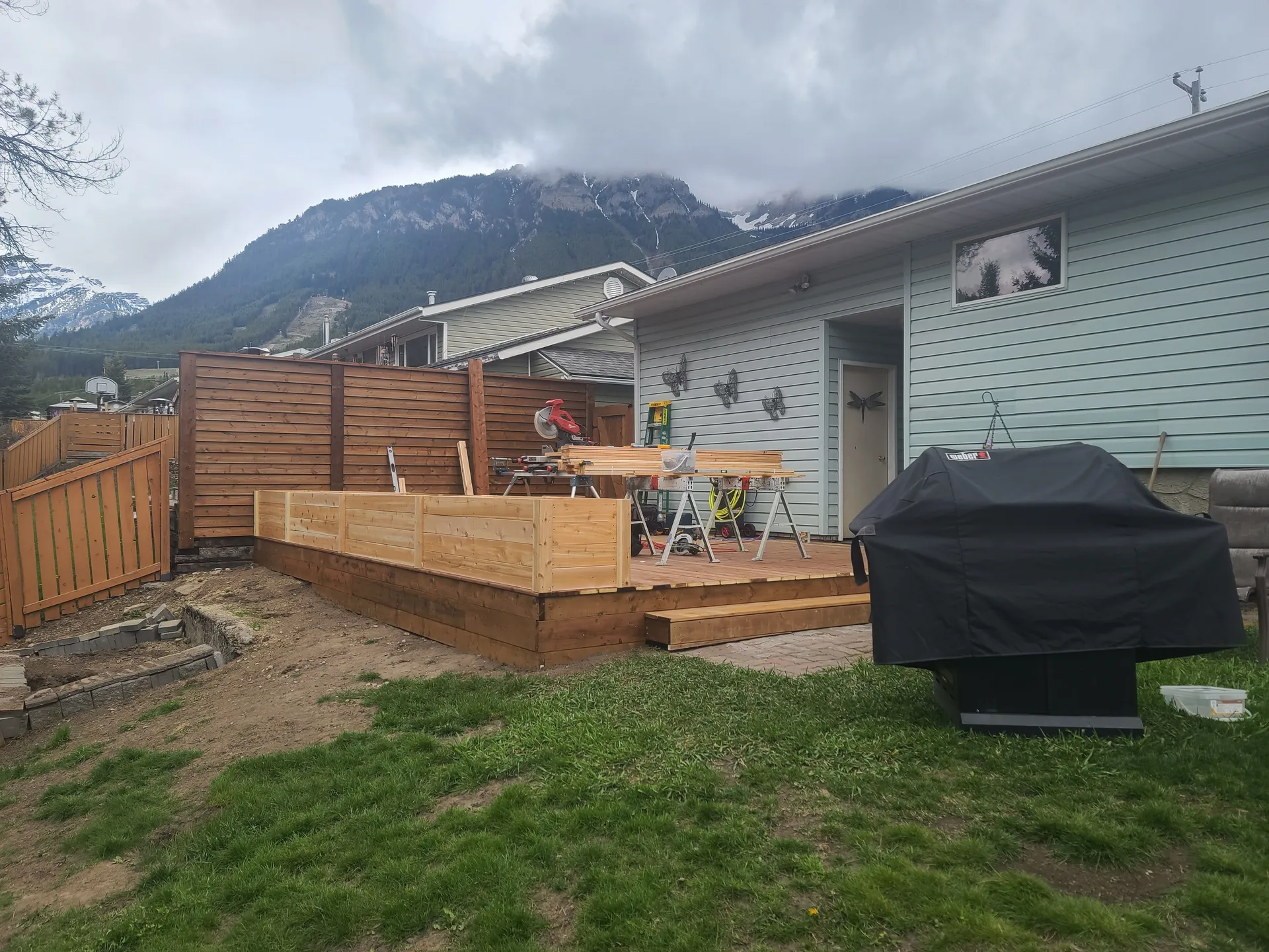 Deck boards in progress beside the house